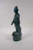 A Chinese emerald green glazed pottery figure of Quan Yin, standing on a fish, impressed mark to