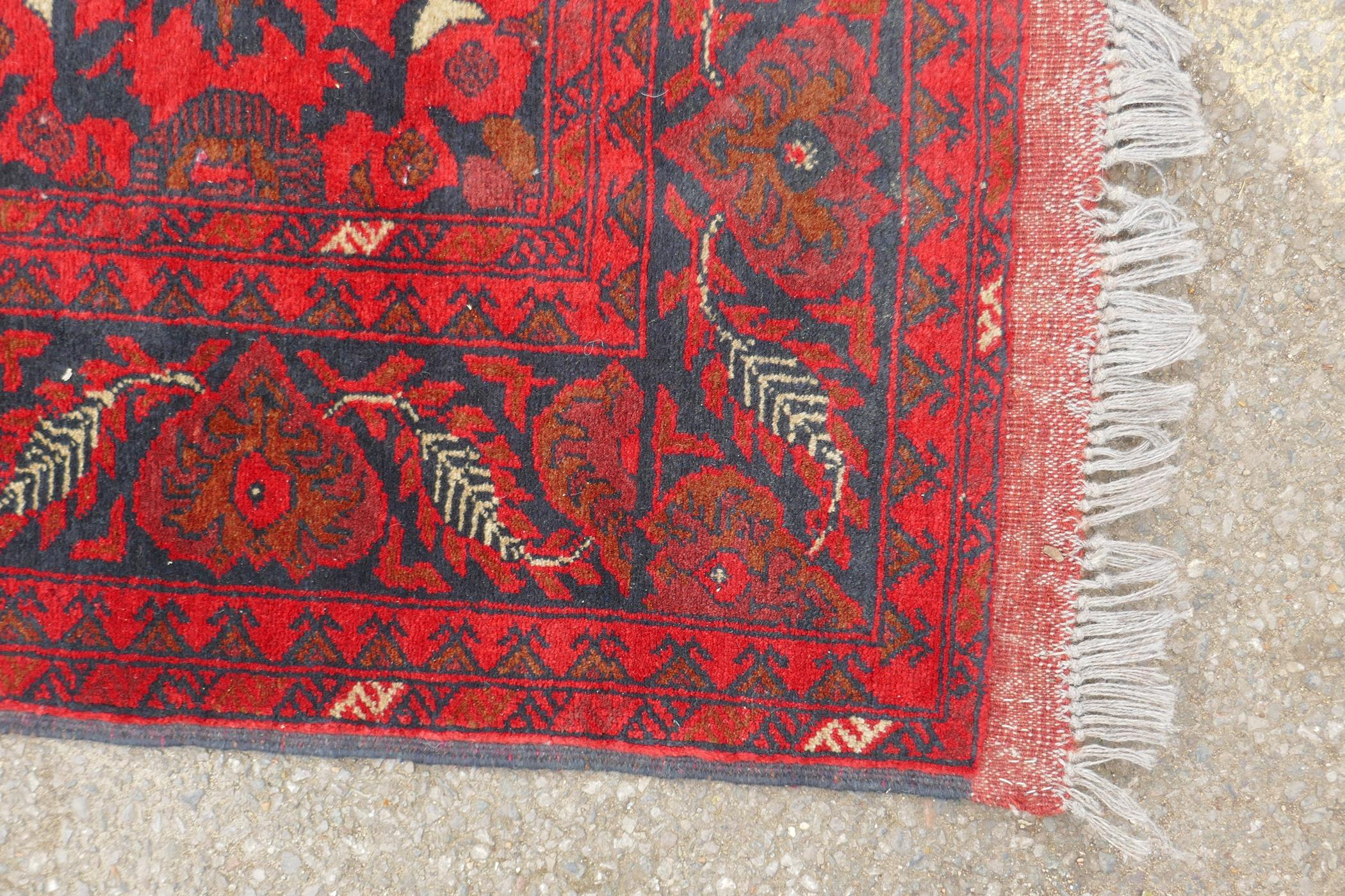 A Persian rich red ground wool runner with a floral medallion design and black borders, 33" x 116" - Image 4 of 5