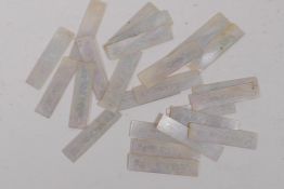 Twenty four engraved mother of pearl gaming chips, each 4.5cm long
