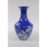 A blue ground porcelain vase with ribbed neck and raised white enamel decoration of birds, Chinese