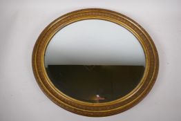 A gilt framed oval wall mirror with bevelled glass, 45 x 50cms