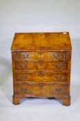 A Georgian style burr walnut bureau, the fall front with shaped interior comprising drawers and