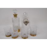 An etched and cut glass decanter and four matching tumblers, and a square cut glass decanter with