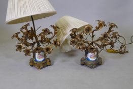 A pair of table lamps with ormolu mounts and porcelain bodies decorated in the manner of Sevres, one