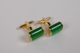 A pair of gilt metal cufflinks set with green stones