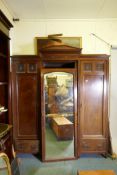 A Maple & Co mahogany triple wardrobe, two hanging cupboards flanking a central mirrored door, the