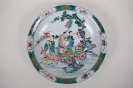 A famille vert porcelain charger decorated with female travellers and deer drawn carts, Chinese
