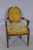 A C19th style spoon back open armchair with carved details, raised on fluted supports