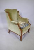 A C19th inlaid mahogany framed wing armchair with swept arms on square tapered supports and castors