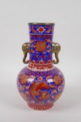 A blue ground vase with two gilt elephant mask handles and iron red phoenix and floral decoration,