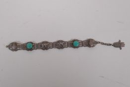 An Indian white metal and turquoise bracelet decorated with elephants and the hand of fatima, 21cm