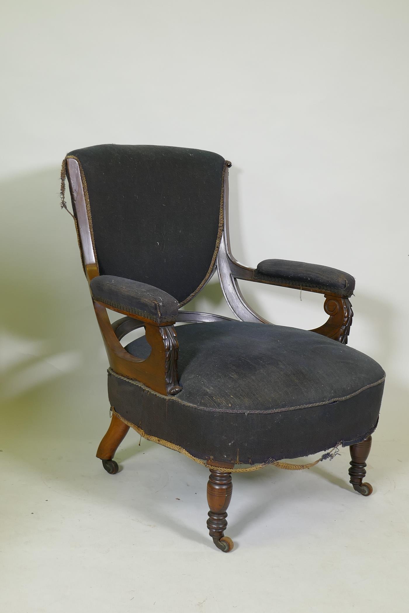 A Victorian show frame rosewood arm chair, with carved arms, raised on turned supports with brass