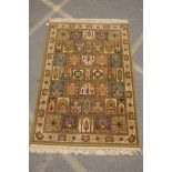 A Persian olive green wool rug with a mirrored panelled design, 142 x 202cms