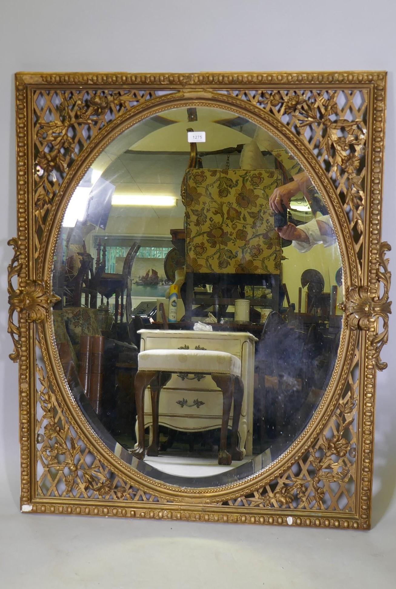 A C19th Continental giltwood and plaster wall mirror, with bevelled glass and pierced spandrels,
