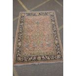 A pink ground Persian rug with a tree of life design and blue borders, 170 x 220cms