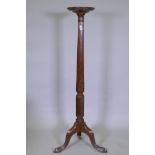 A mahogany torchere with carved and fluted column and tripod supports, 26 x 132cms