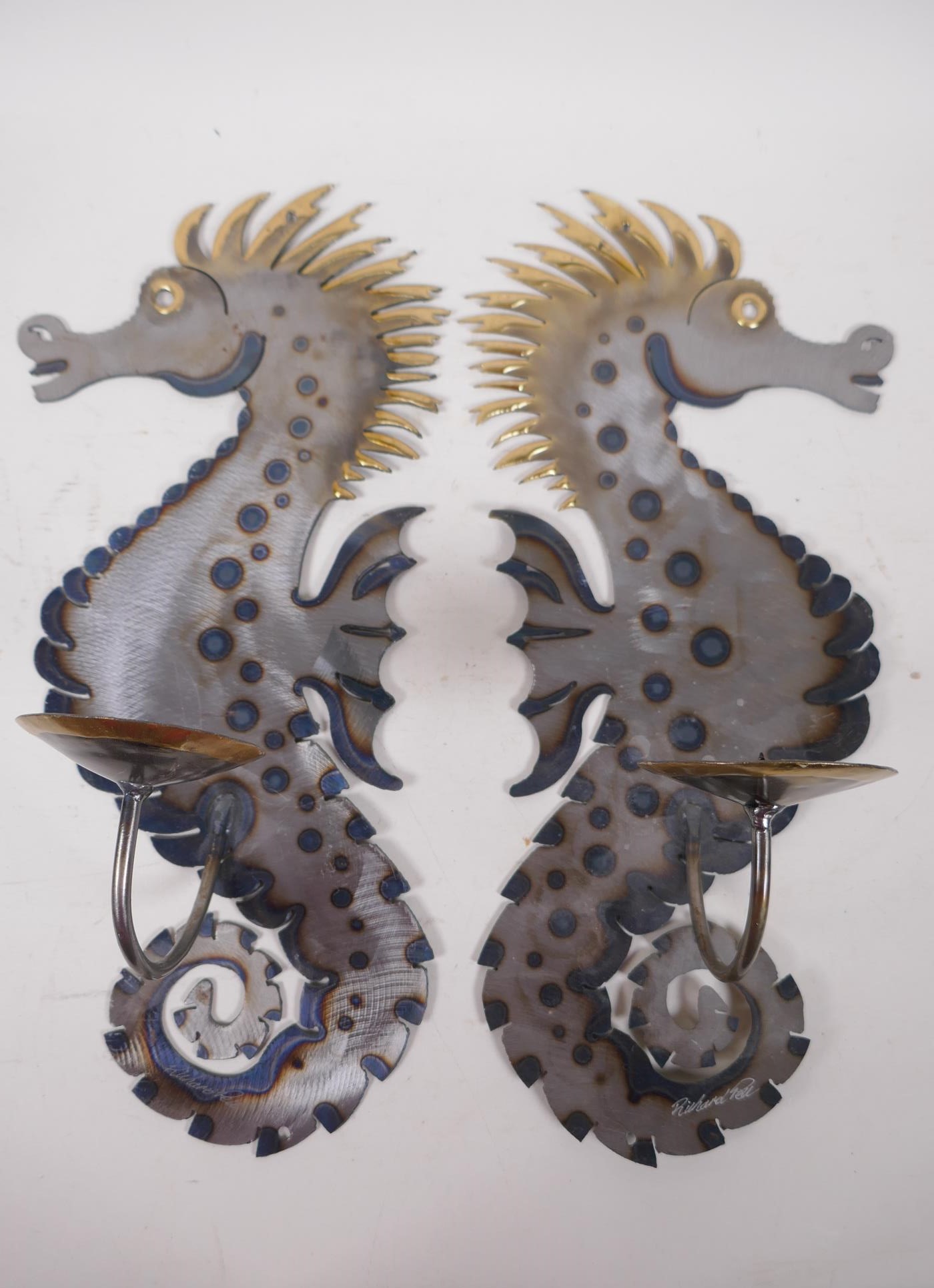 A pair of decorative 'seahorse' candle wall brackets, signed Richard Pell, 42cm high