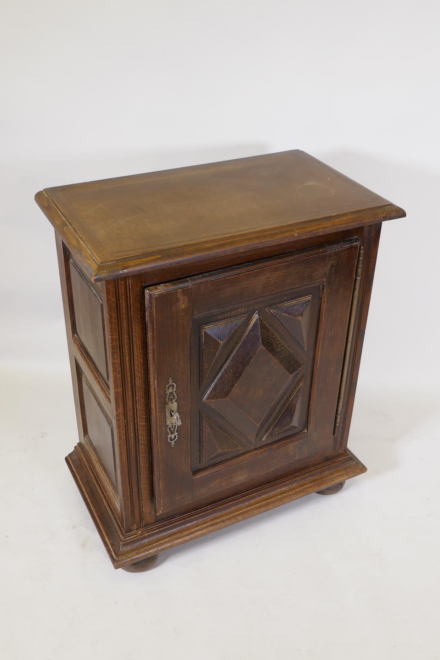 A French oak side cupboard, the single door with moulded decoration, raised on bun feet, 70 x 40 x - Image 2 of 3