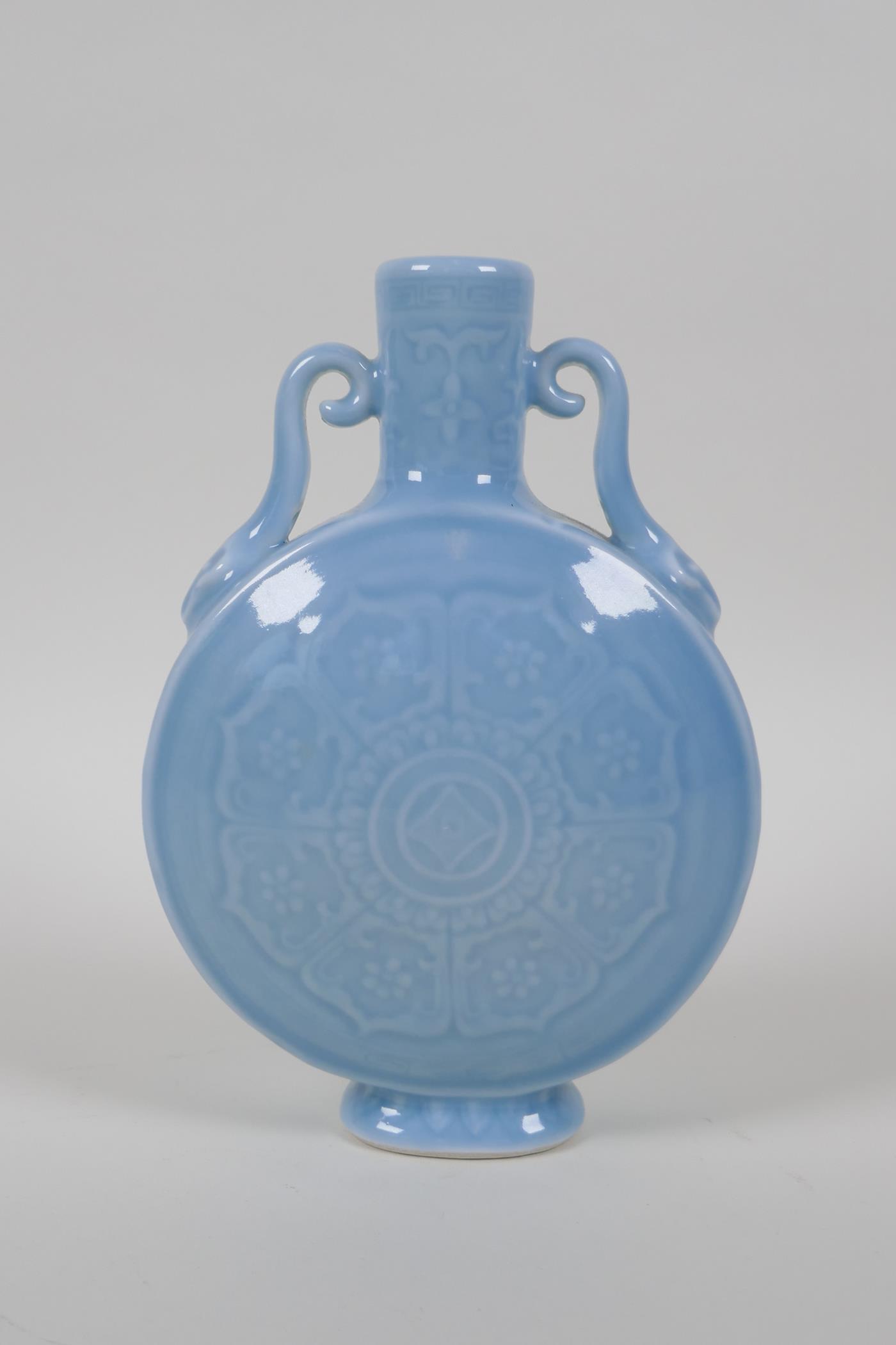 A duck egg blue glazed porcelain moon flask with two handles and underglaze lotus flower decoration,