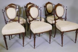 A set of six C19th walnut side chairs with carved and inlaid decoration in the Aesthetic style,