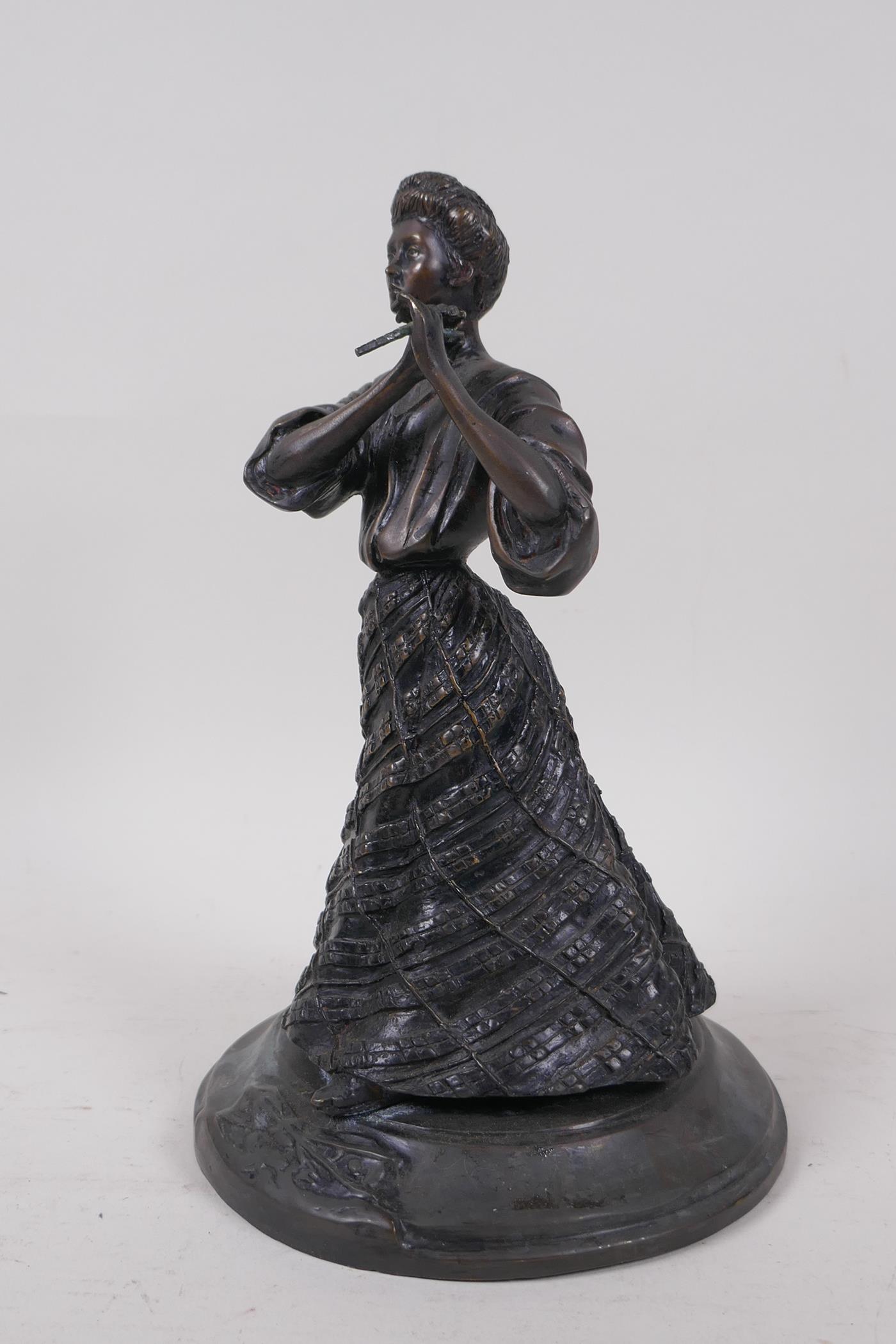 An antique bronze of an American woman in a skirt, 23cm high, AF parasol missing
