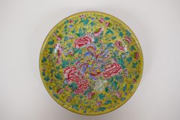 A polychrome porcelain cabinet dish decorated with butterflies and flowers on a yellow ground,