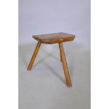 An antique elm milking stool, 38cm high