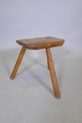 An antique elm milking stool, 38cm high