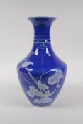 A blue ground porcelain vase with ribbed neck and raised white enamel decoration of birds, Chinese
