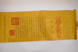 A Chinese calligraphy scroll on gilt silk, 144 x 33cms