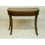 A Georgian mahogany D shaped tea table with reeded edge and cross-banded top, raised on carved sabre