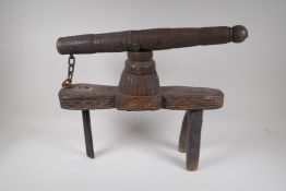 An Indian carved hardwood juicer/press, repair to leg, 44cm high x 54cm long