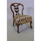 A Victorian walnut parlour chair with shaped and carved back, raised on cabriole supports