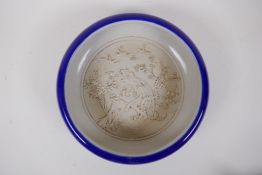 A Chinese powder blue glazed porcelain bowl with rolled rim, the interior with raised phoenix