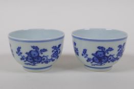 A pair of blue and white porcelain tea bowls decorated with branches bearing fruit, Chinese Qianlong