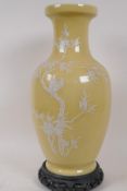 A Jingdezhen Chinese yellow ground porcelain vase decorated in pate sur pate with birds in a tree in