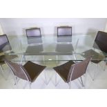 A glass top dining table with chrome base and splay supports and a set of six chairs en suite with