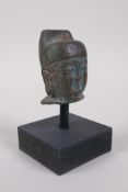 A Chinese bronze headbust of Buddha, mounted on a display stand, 12cm high