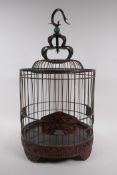 A Chinese bird cage with carved decorative frieze depicting birds and squirrels amongst foliage,