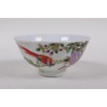 A polychrome porcelain tea bowl with bird and flower decoration, character inscription verso,