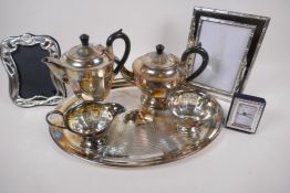 An oval silver plated tray, 40cm x 30cm, a four piece silver plated tea set, two silver plated photo