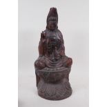 A hardwood carving of Quan Yin, seated upon a lotus throne, 40cm high