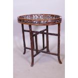 An oriental rosewood tray table on stand, the tray with carved and pierced gallery, the folding
