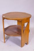 An Art Deco walnut shaped top two tier occasional table raised on three pierced supports, 59cm x