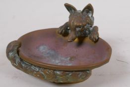 A brass ashtray cast as a fox curled around a water bowl, 10cm wide