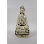 A blanc de chine porcelain figure of Quan Yin seated on a lotus flower, impressed Chinese seal marks