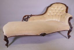 A Victorian serpentine front walnut chaise longue with carved and pierced back, raised on cabriole