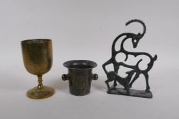 A brass goblet with engraved decoration, a mortar shaped vessel, 10cm high, and a stylised figure