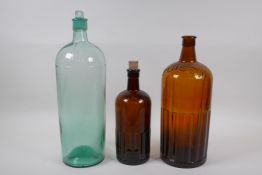 Two vintage brown ribbed glass poison bottles and a similar green glass bottle, largest 39cm high