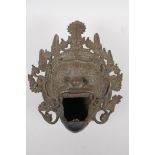 An antique Balinese bronze censer on tripod supports in the form of a garruda mask, 24cm x 28cm